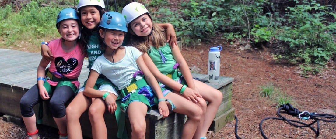 A group of Girl Scouts wearing climbing helmets