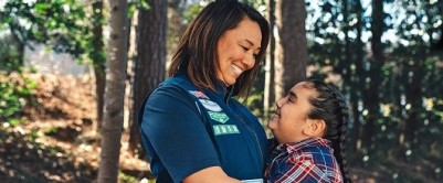 A Girl Scout hugging a Girl Scout volunteer A Girl Scout hugging a Girl Scout volunteer