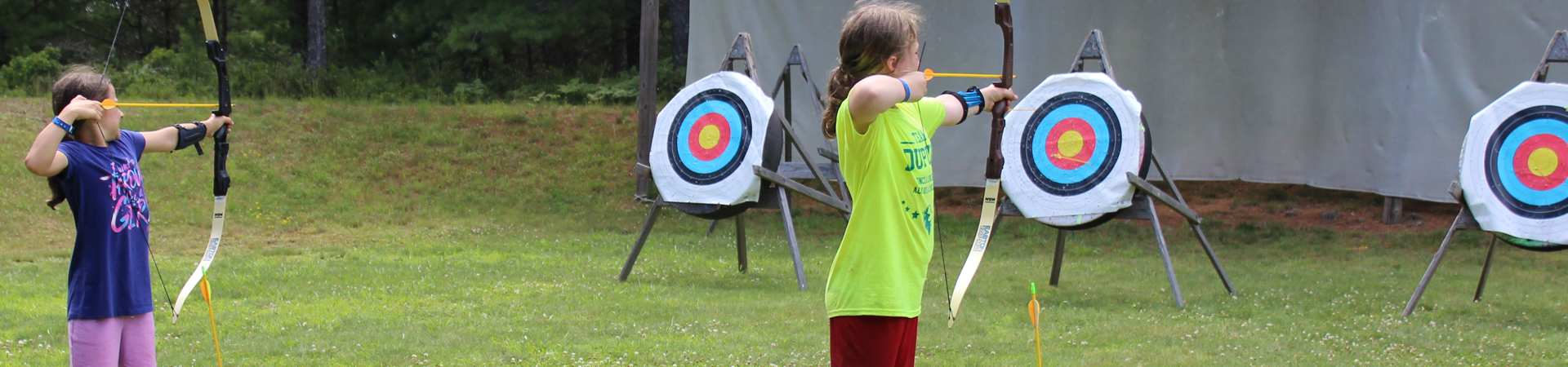 girl at camp doing archery 