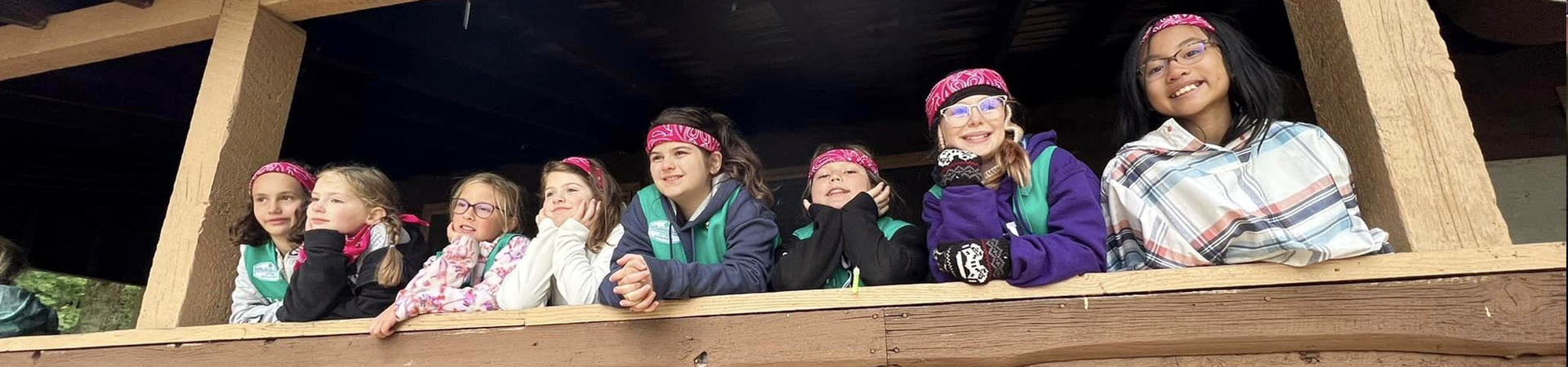  group of girl scouts in vests and bandanas at camp 