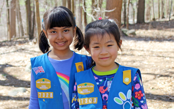 Girl Scout Daisies hugging in uniform