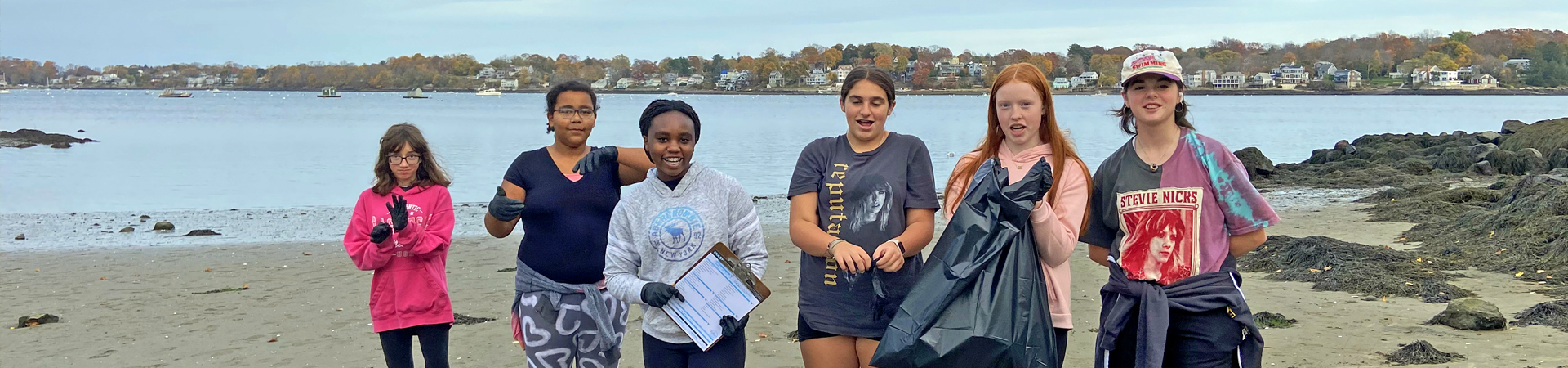  group of girls picking up trash on the beach 