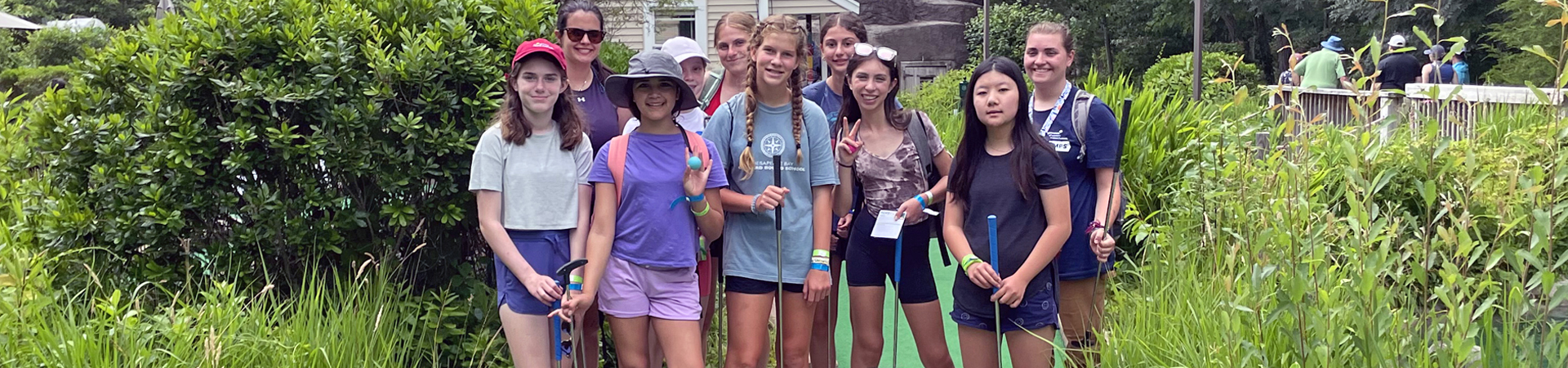  girl scout troop outside doing mini golf 