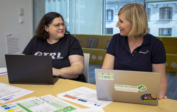 two women with laptops working together