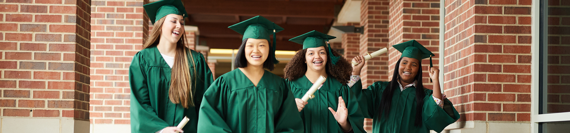  group of senior girls in caps and gowns with diplomas  